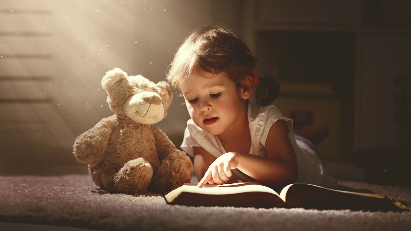 Child reading to her toy