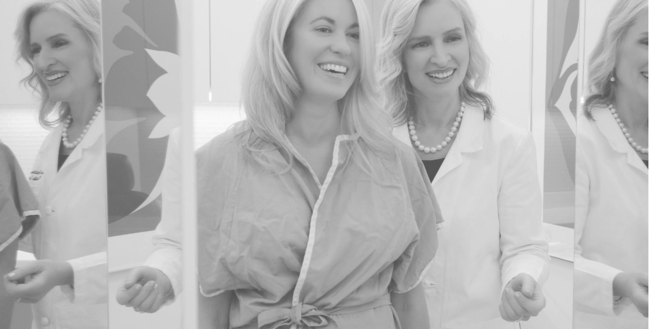 Black and white photo of Dr. Hutchinson and patient smiling and  looking in mirror