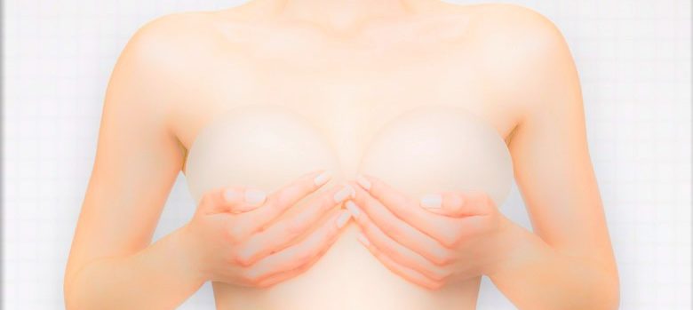 woman holding breast implants against her body