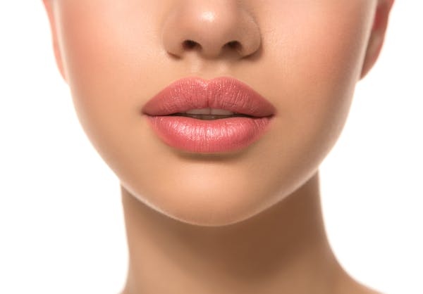 Close up of a woman's lips with pink lipstick on