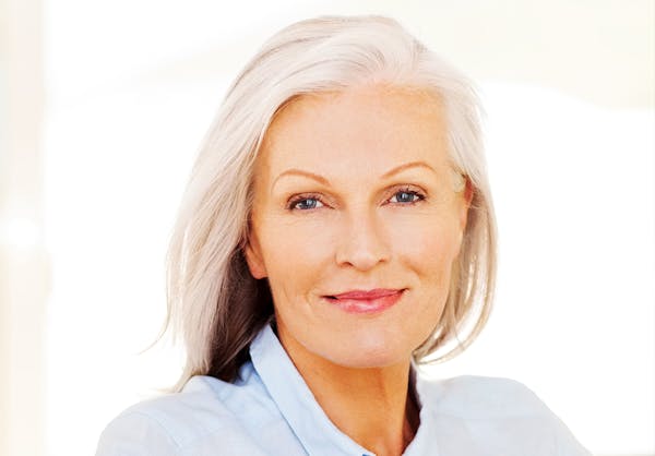 Older woman with sculpted facial features in a blue blouse