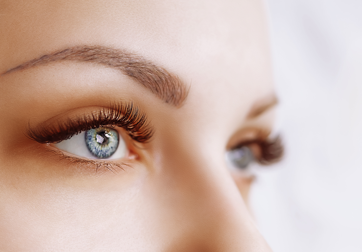 Close up of a white woman's blue eyes and sculpted eyebrows