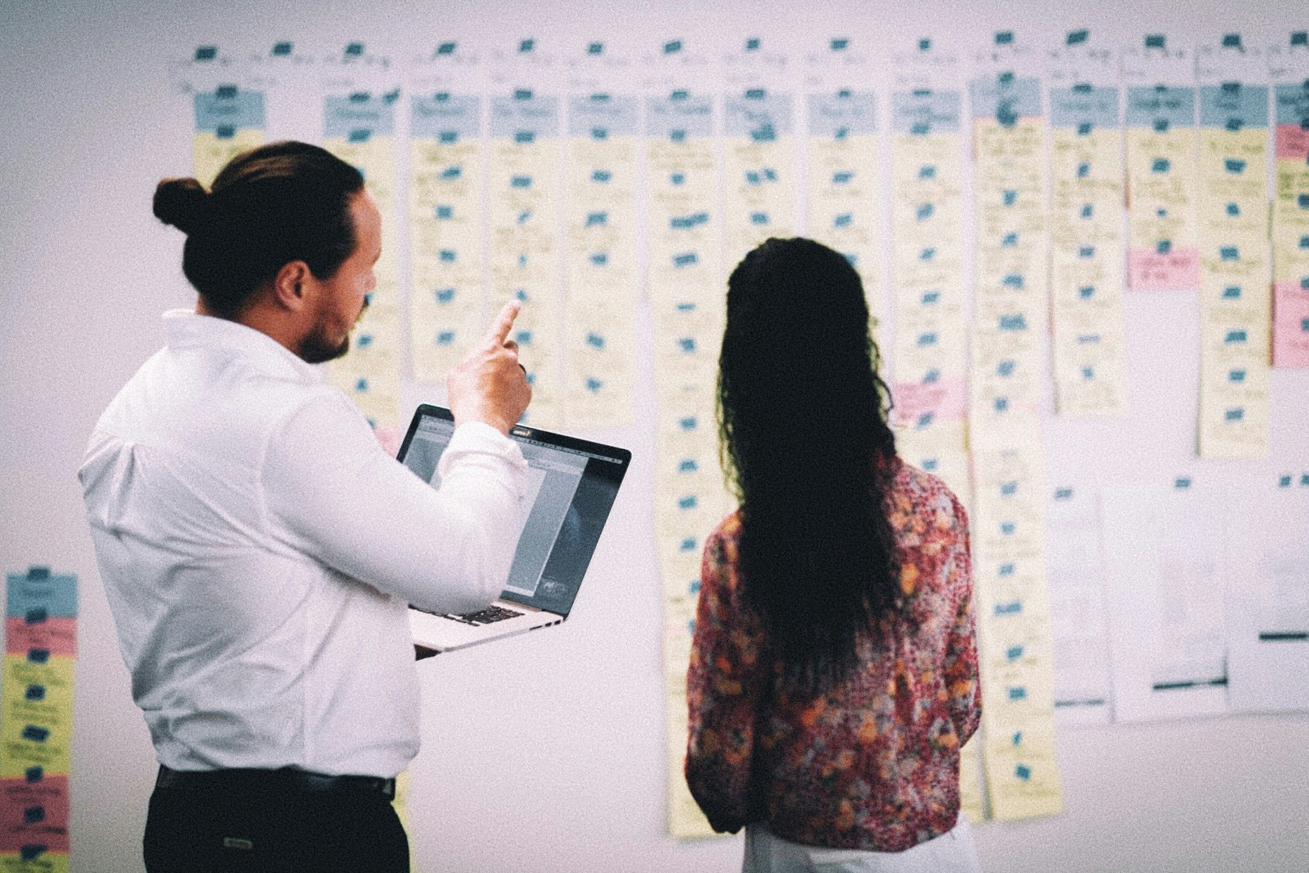 Couple discuss cards on a wall