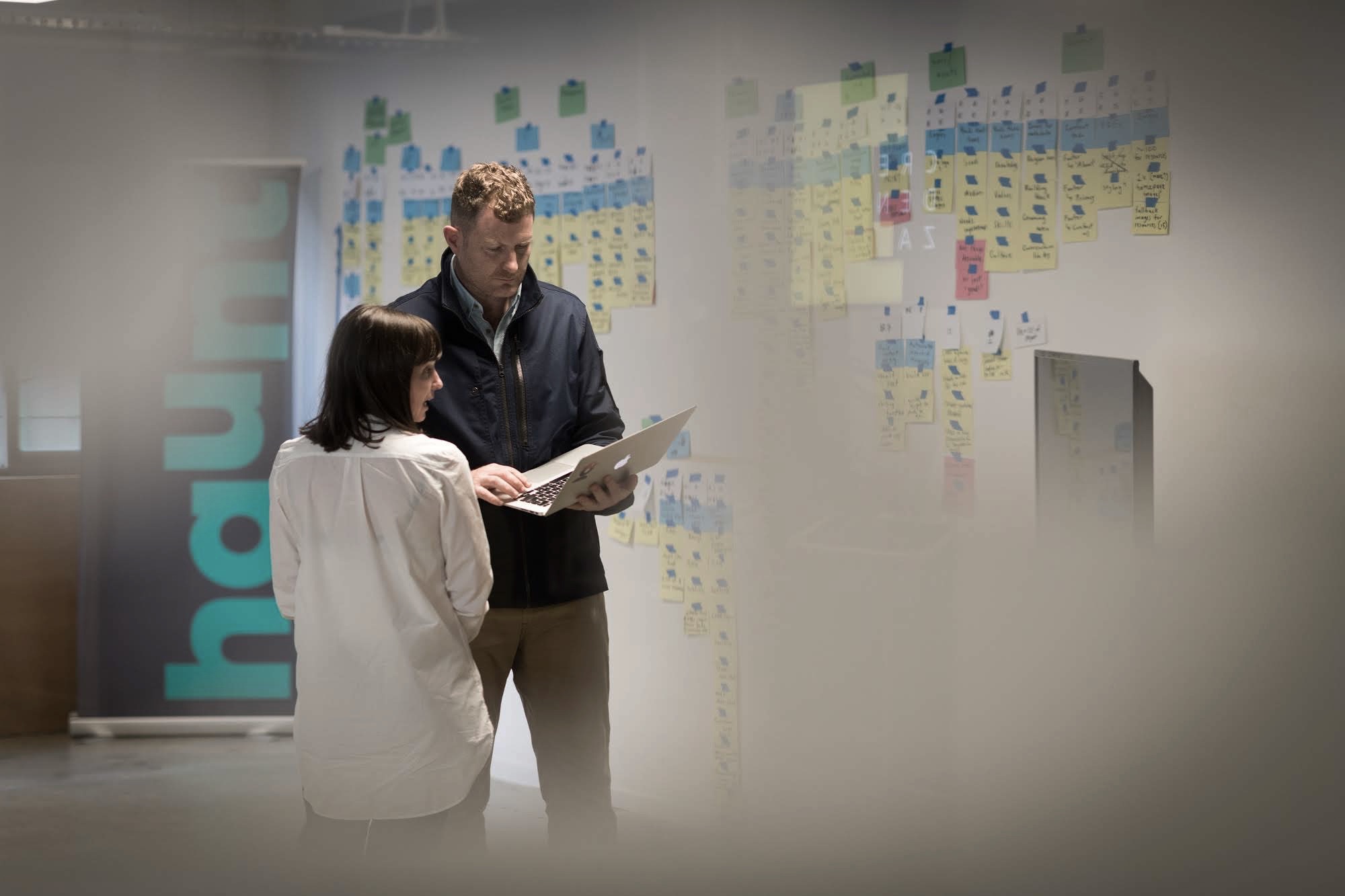 A man and lady look at a laptop