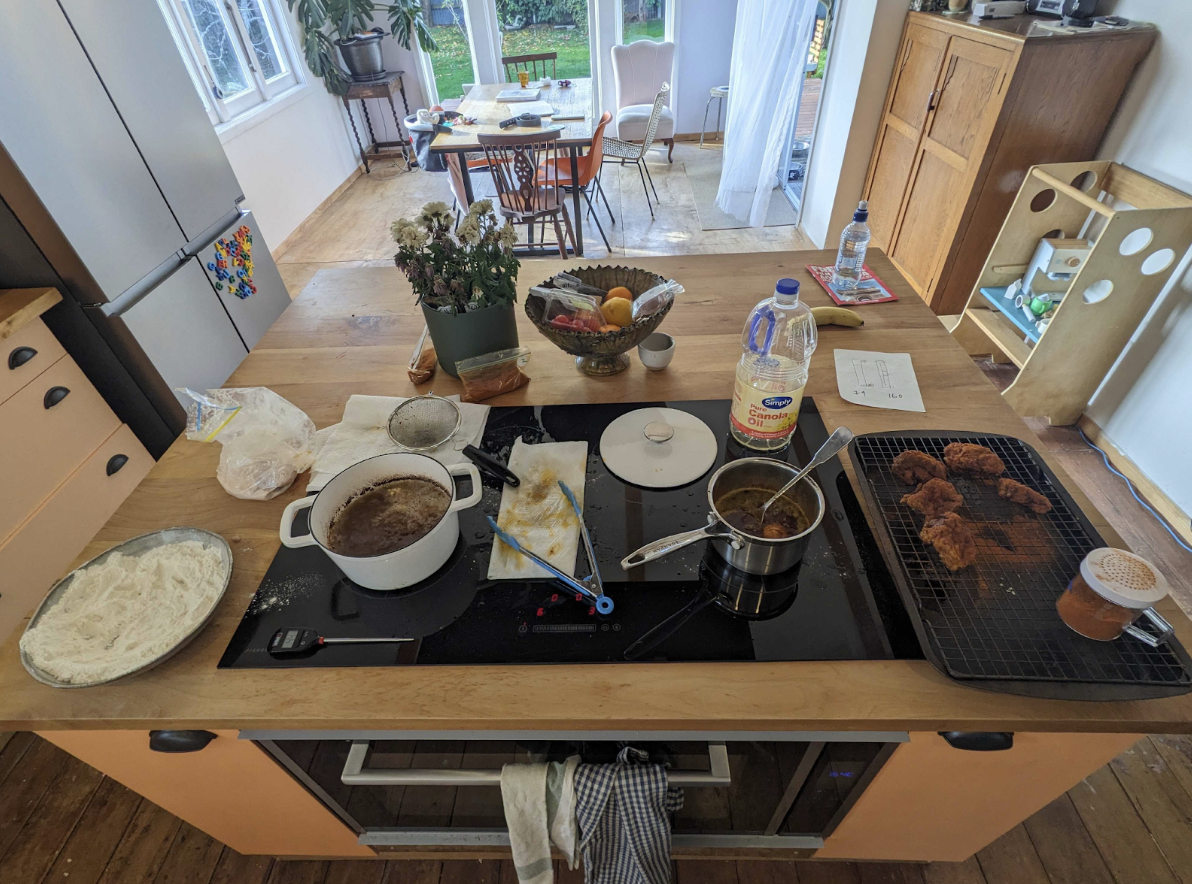 Kitchen top with large frying pot and smaller pot for dipping the cooked chicken