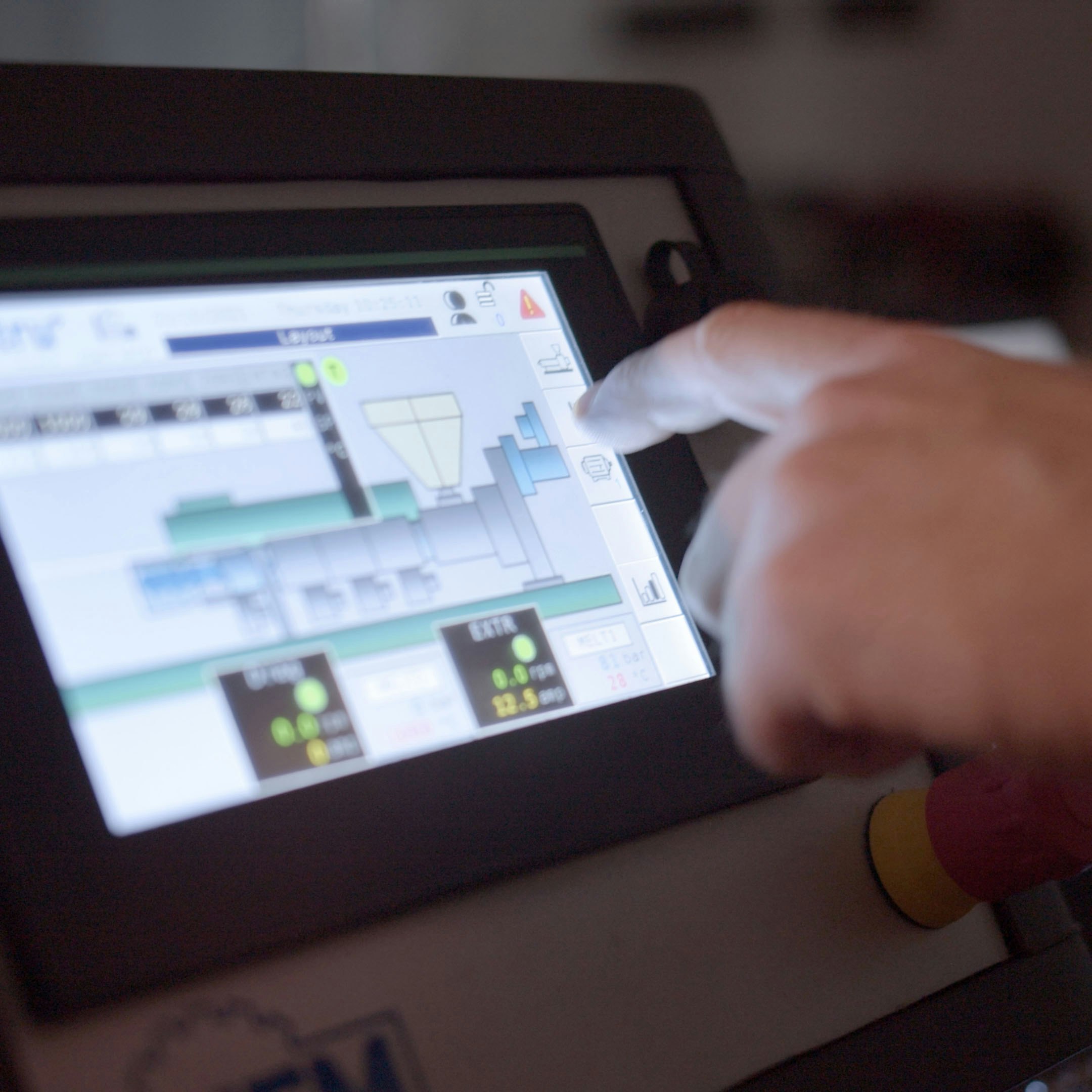 Hand pointing on a monitor showing a production system