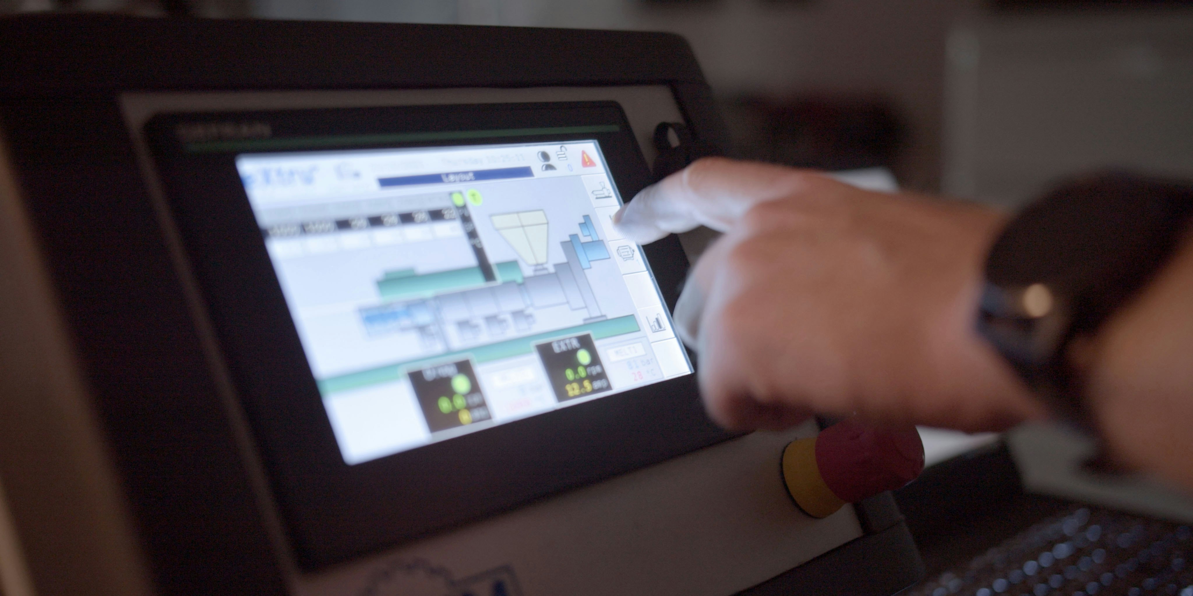 Hand pointing on a monitor showing a production system