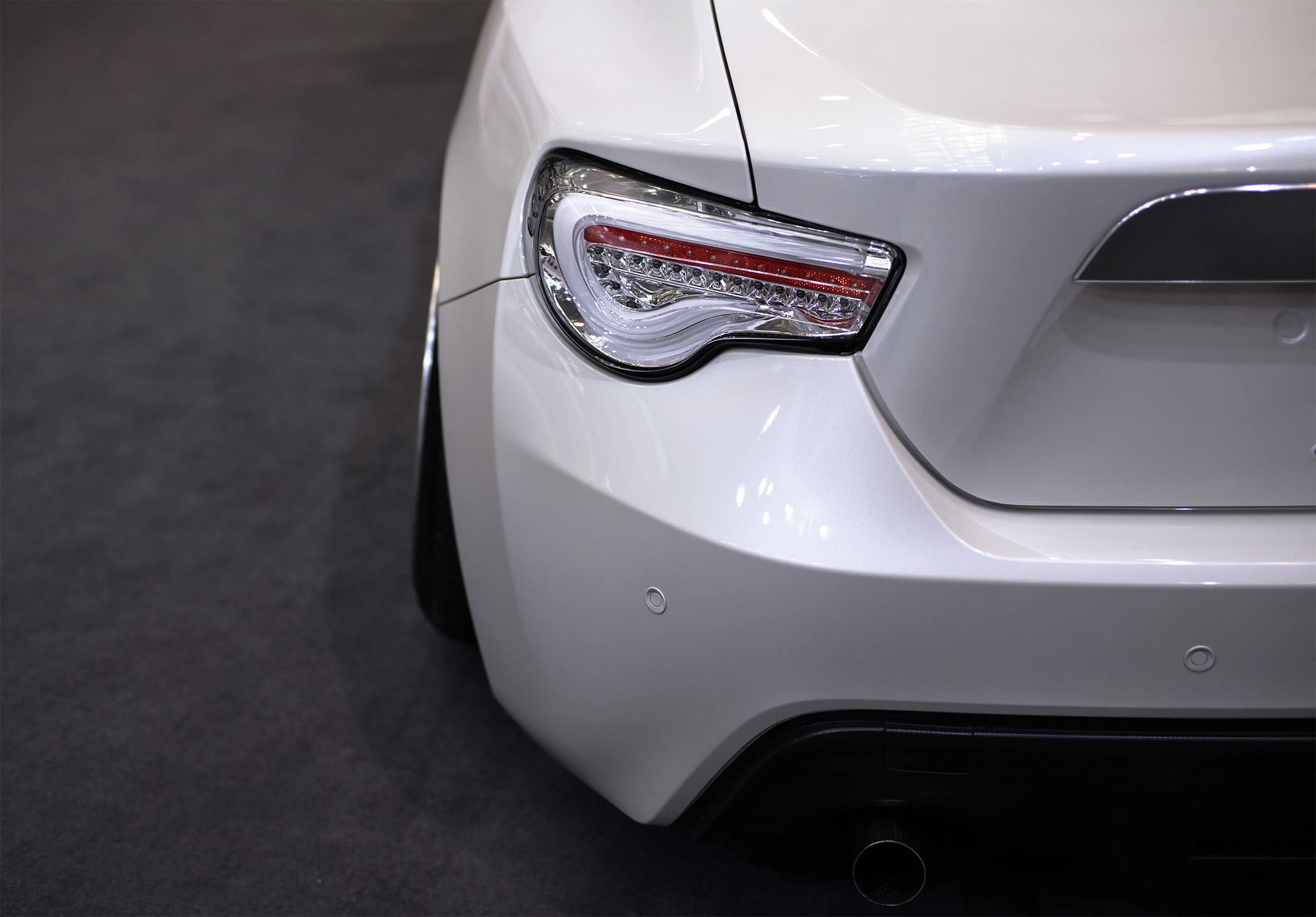 Light and bumper beam on the rear of a white car