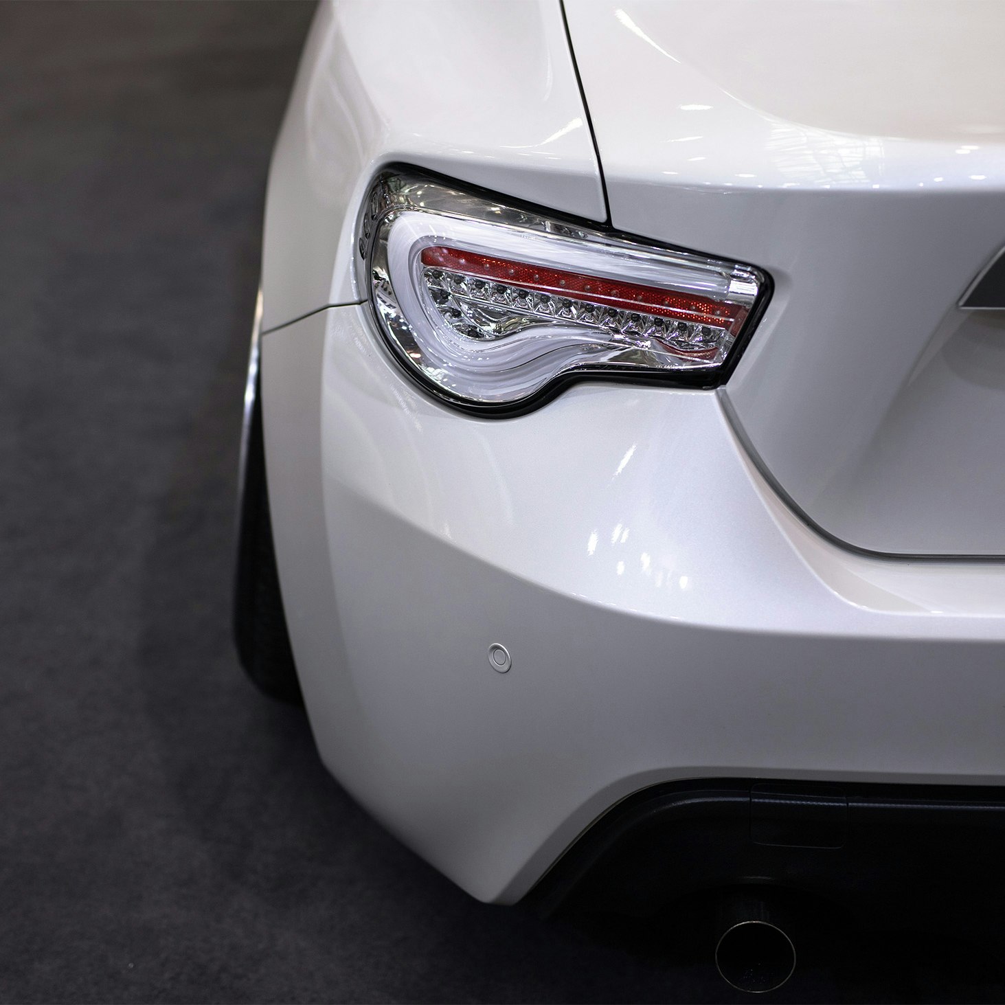 Light and bumper beam on the rear of a white car