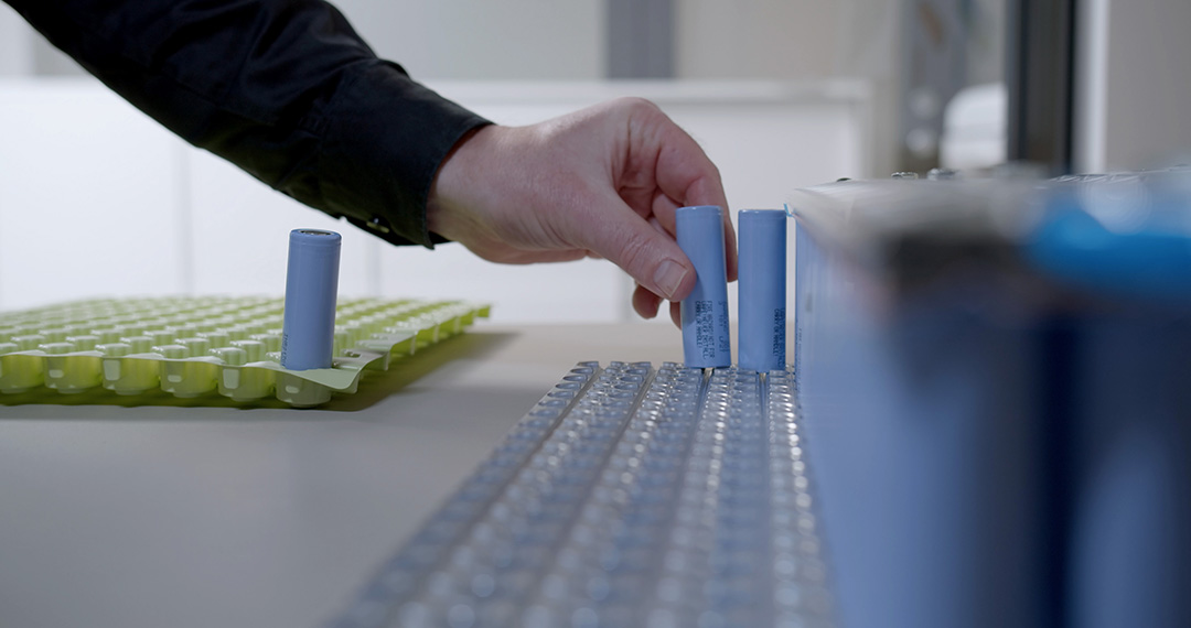 Hand placing battery in battery pack