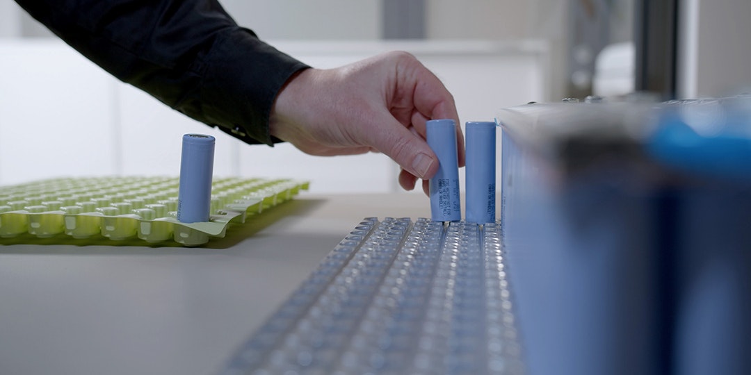 Hand placing battery in battery pack