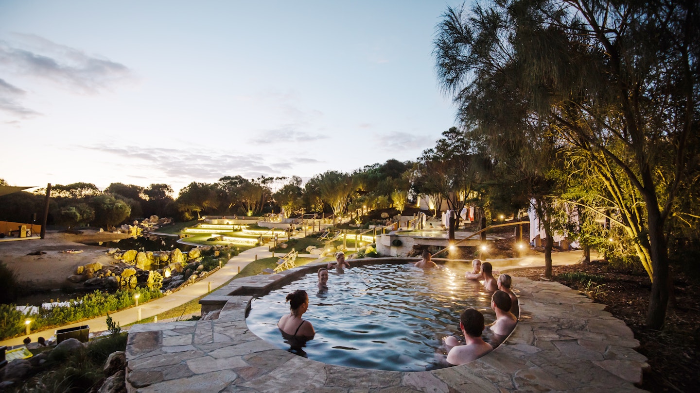 people bathing in amphitheater pools at twilight