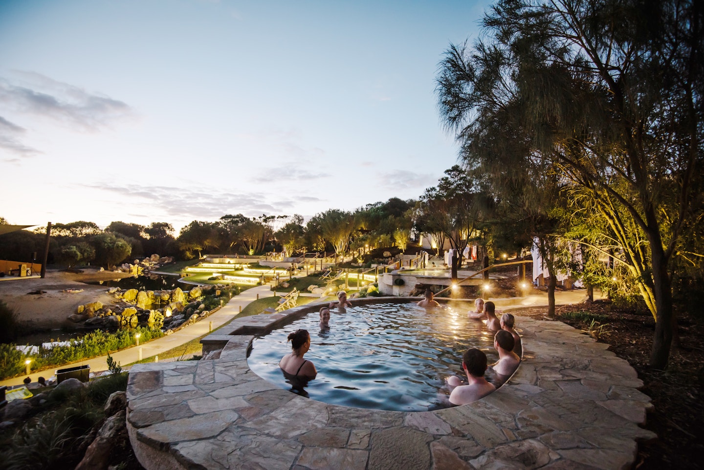 people bathing in amphitheater pools at twilight