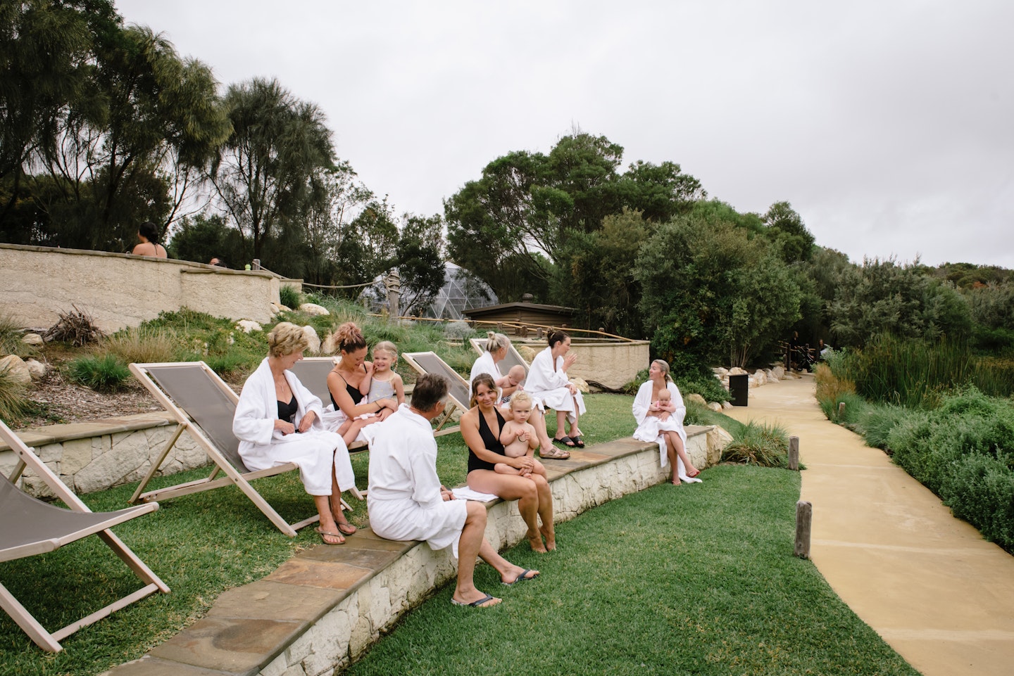 group of women and babies sitting on sun lounges and steps