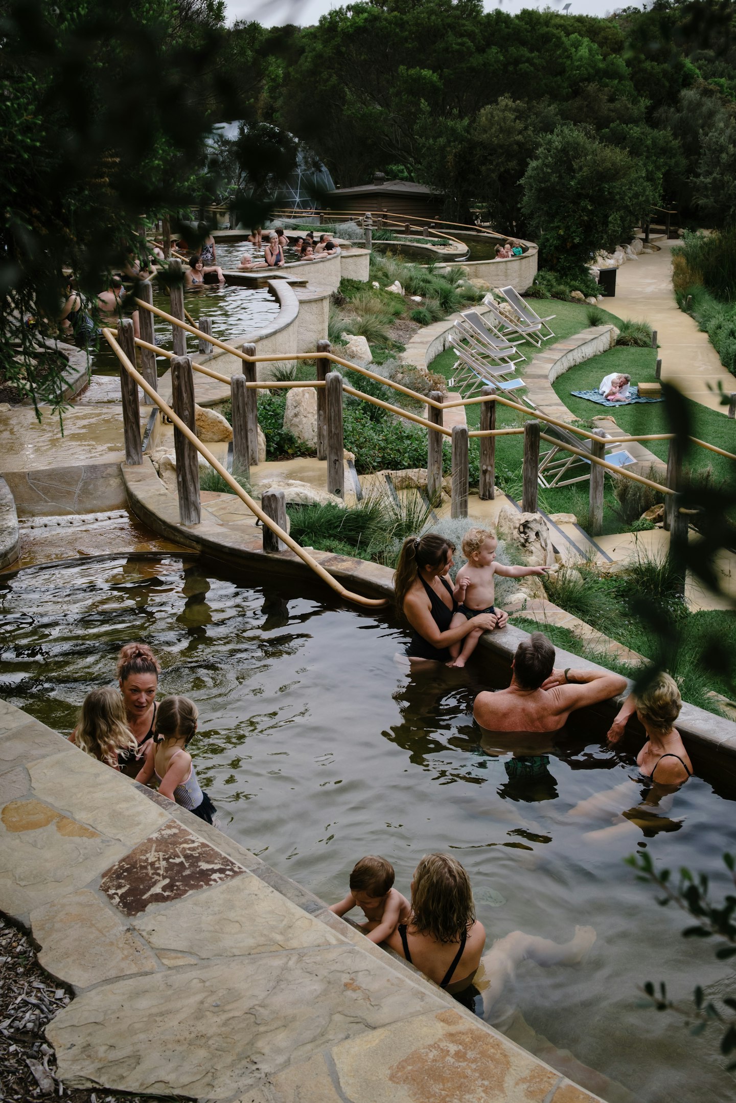 group of adults and babies bathing in geothermal waters 