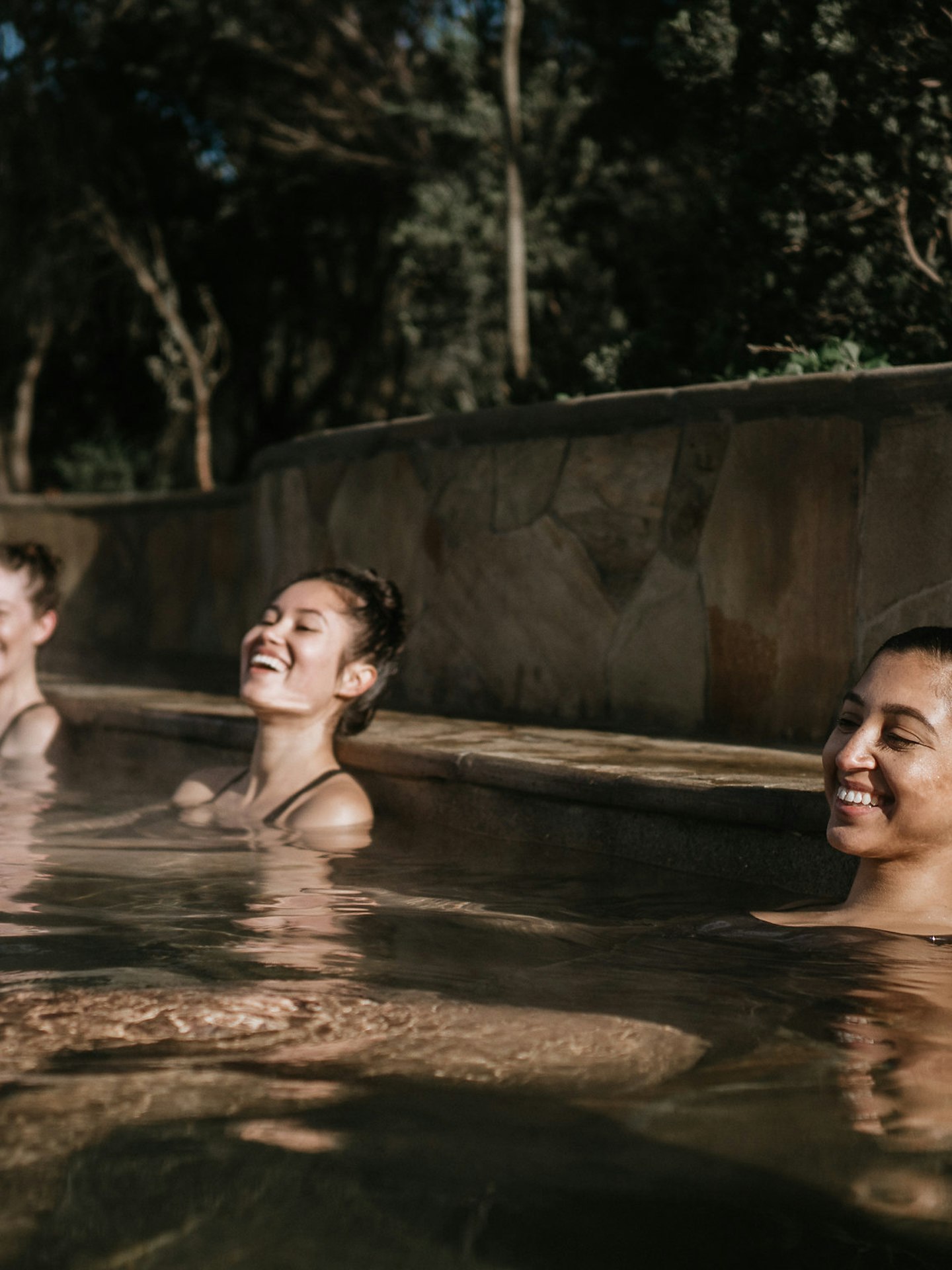 three ladies smiling and relaxing in geothermal pool