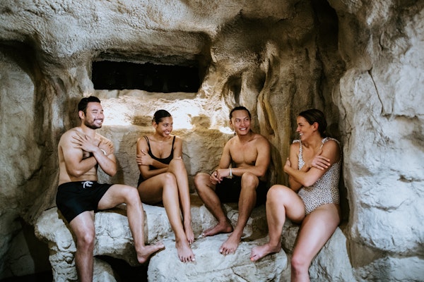 four people in bathing suits sitting in ice cave