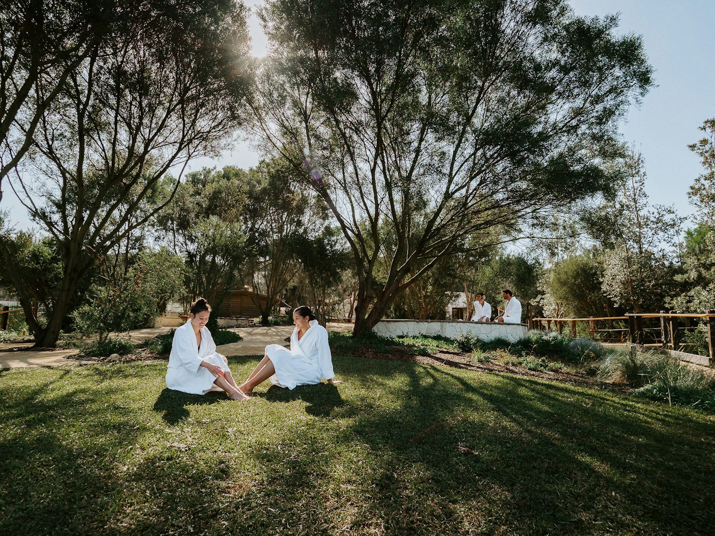 two ladies in robes sitting on grass in natural surrounds