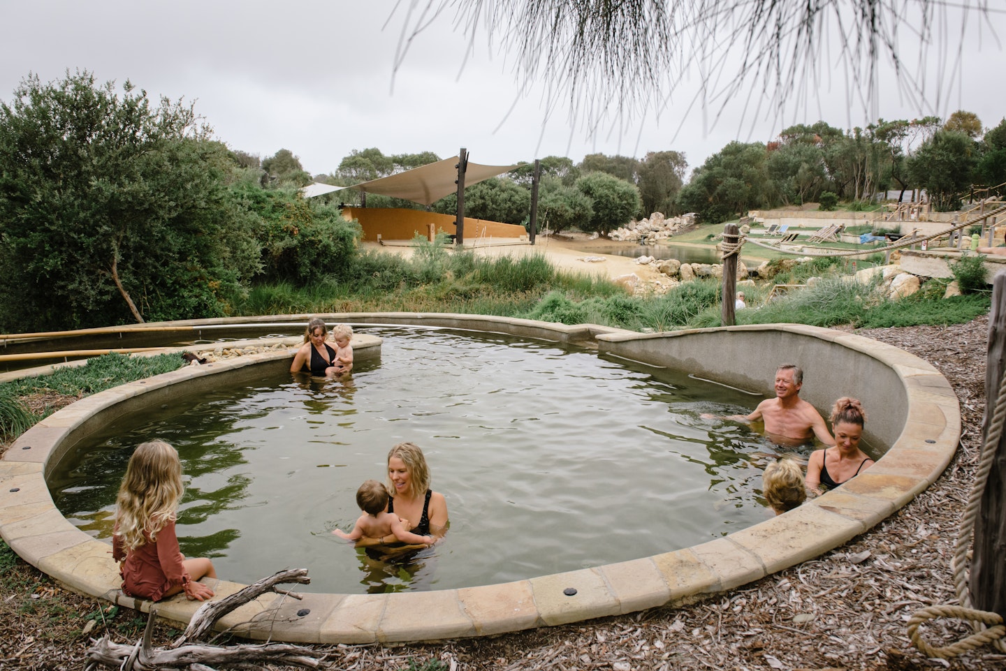 three family groups bathing in watsu pool overlooking amphitheatre