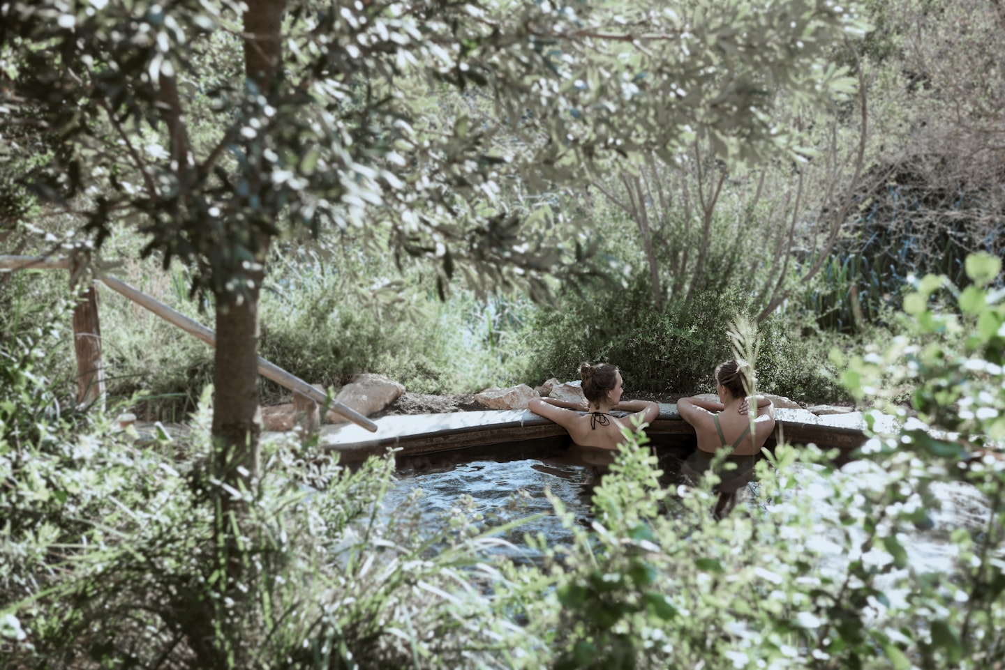 two women in hot pool surrounded by nature