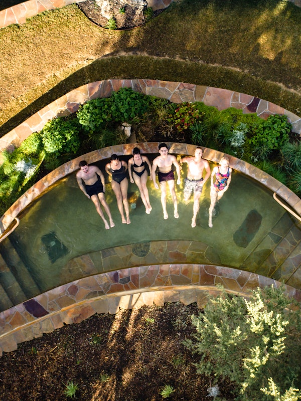 aerial view of six people relaxing in amphitheatre hot pool