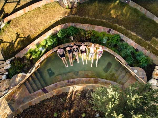 aerial view of six people relaxing in amphitheatre hot pool