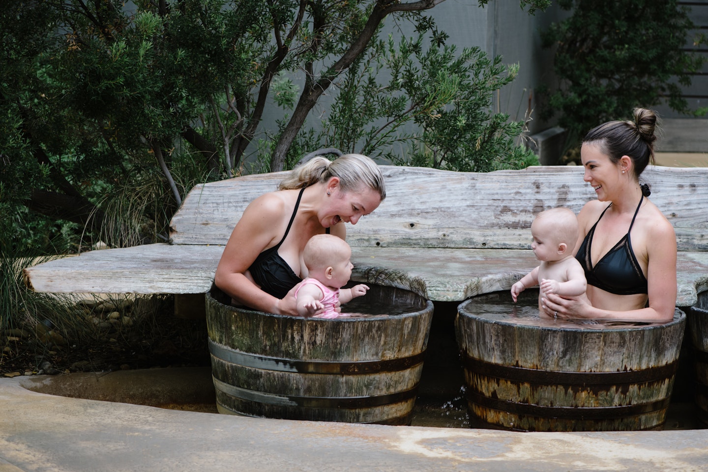 Two women with babies in barrels