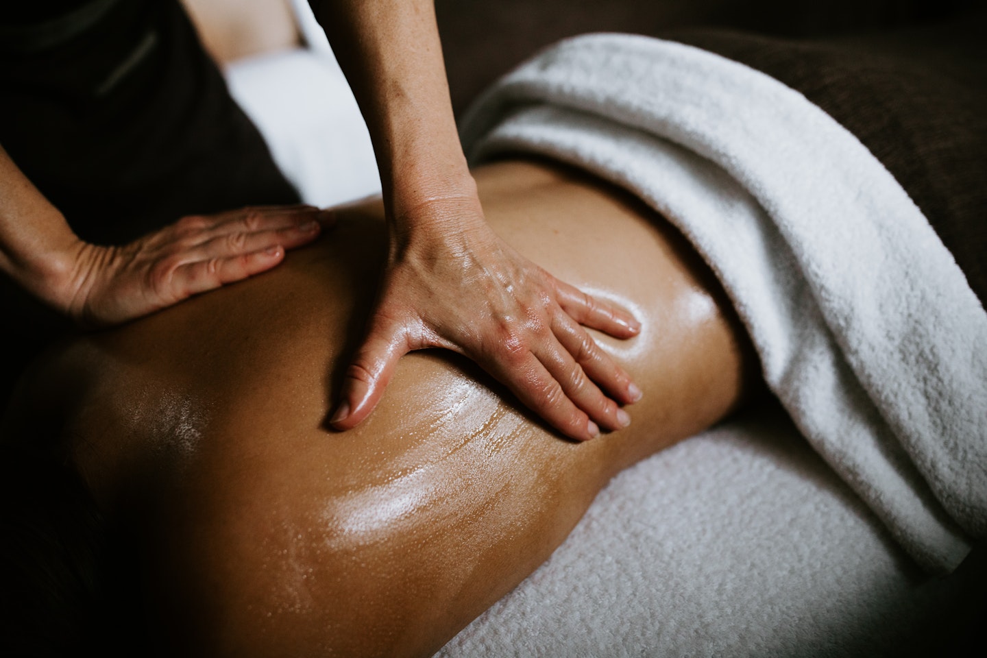 person lying face down on treatment table having a back massage