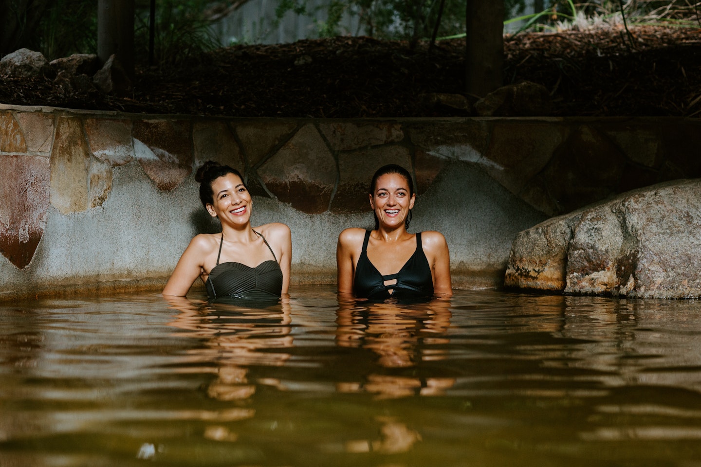 two women sitting in a pool