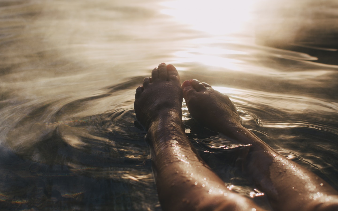 legs and feet stretched out in steamy water