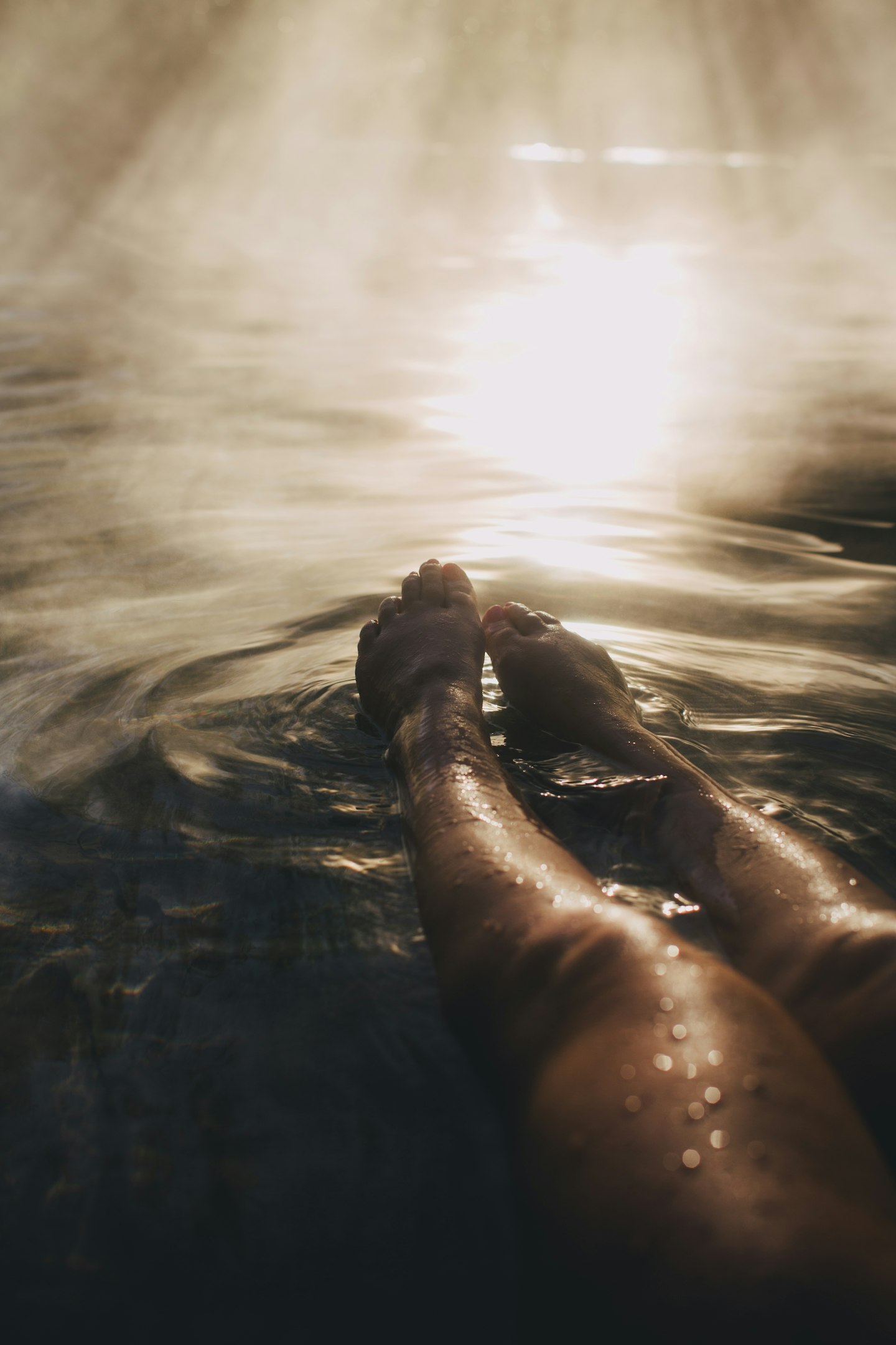 legs and feet stretched out in steamy water