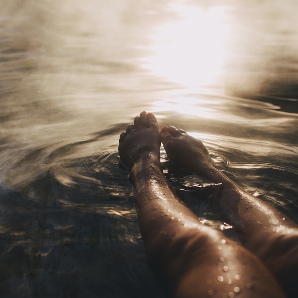 legs and feet stretched out in steamy water