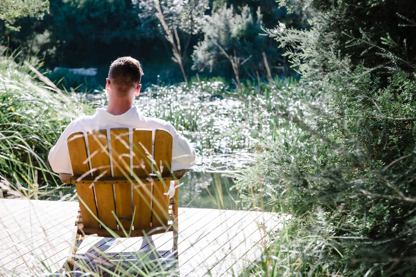 man sitting in a robe looking out towards a lake