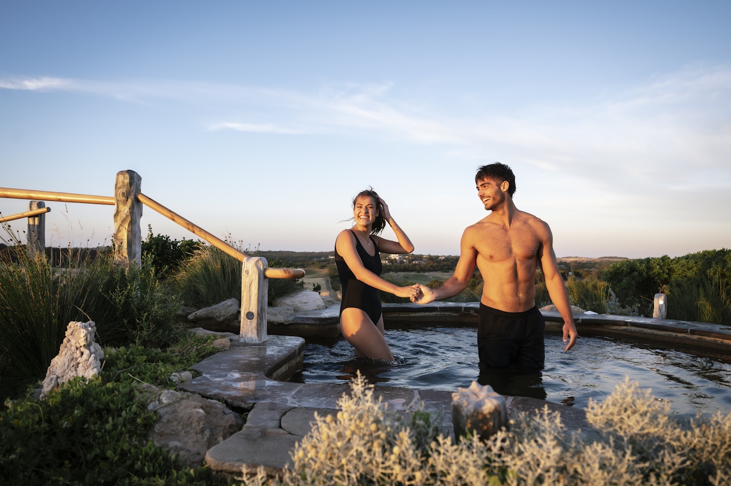 couple holding hands in our Bath House pool