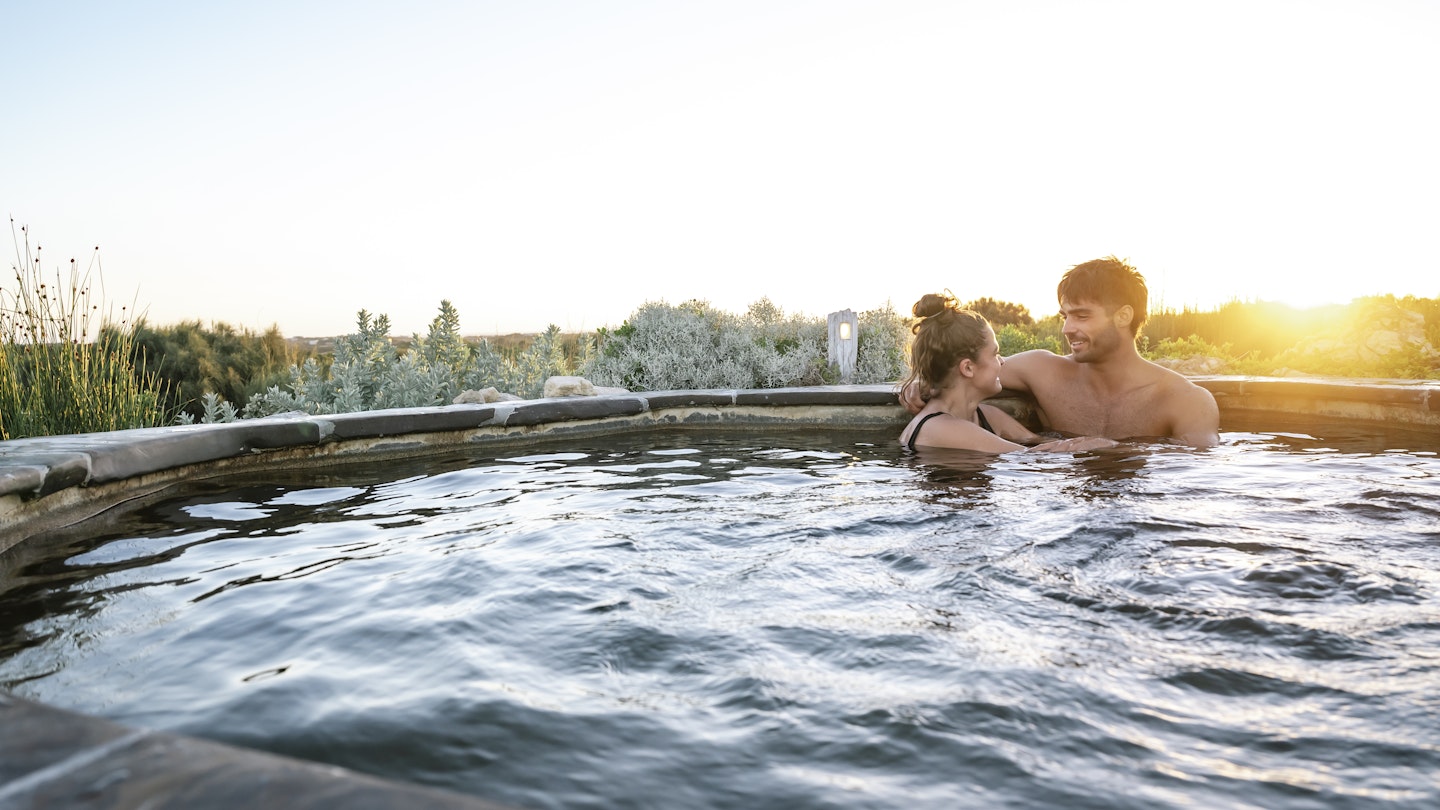 couple sitting in Hilltop geothermal hot pool 
