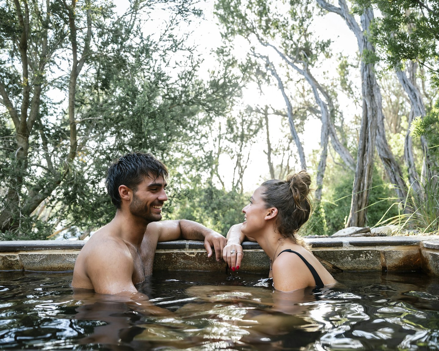 couple sitting in hot geothermal pool