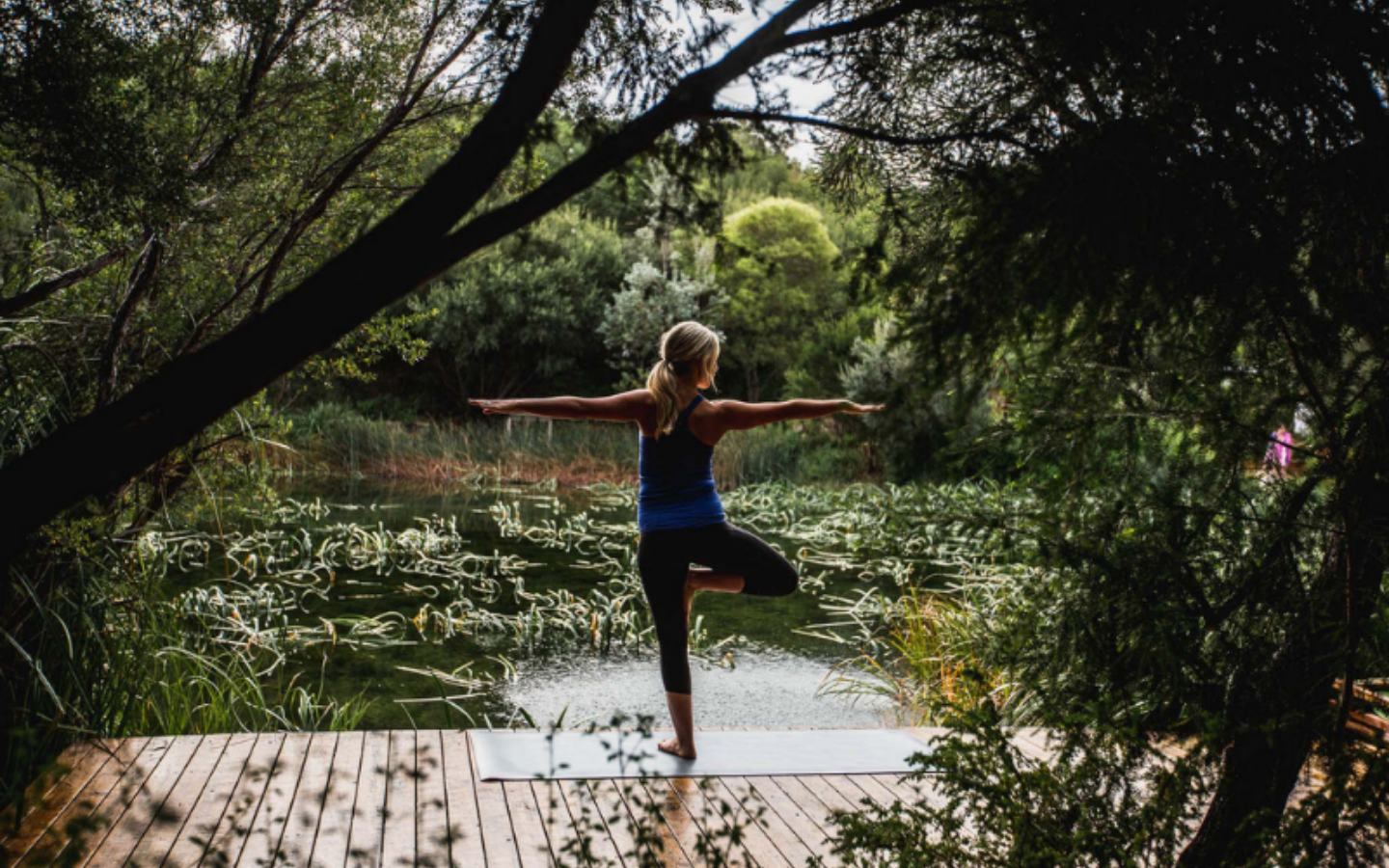 woman doing yoga in front of lake