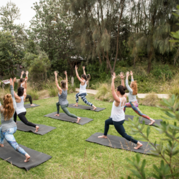 group of women doing yoga in natural surrounds of peninsula hot springs