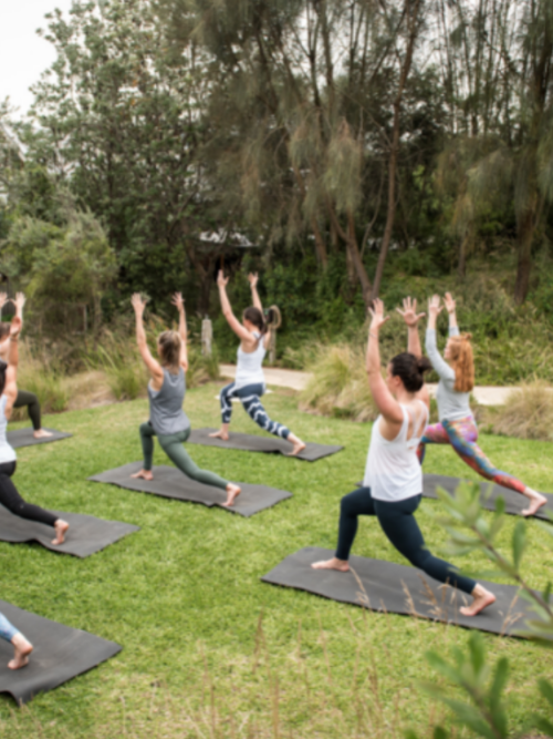 group of women doing yoga in natural surrounds of peninsula hot springs
