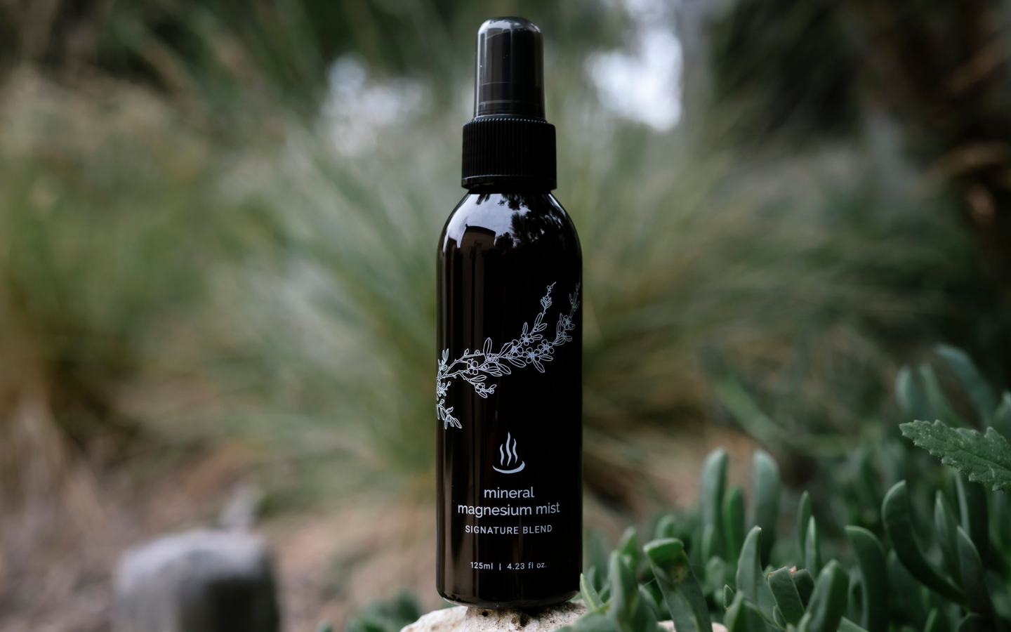 125ml spray bottle of mineral magnesium mist sitting in natural surrounds
