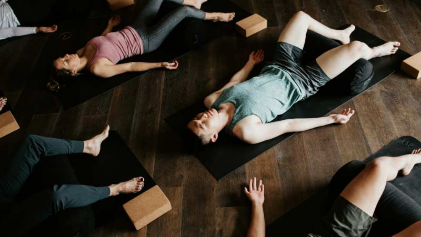 people meditating in shavasana yoga pose