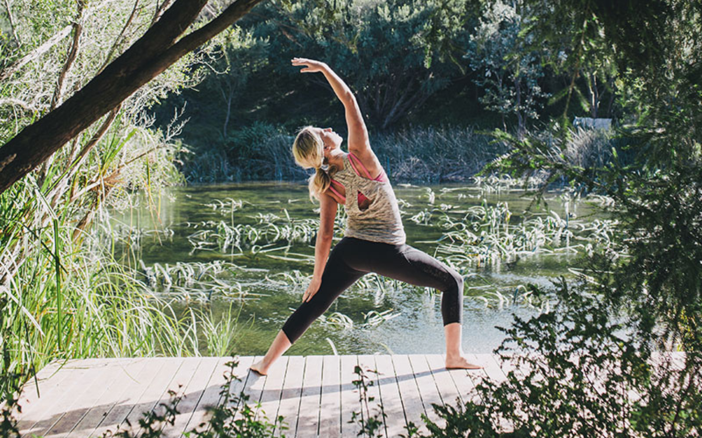 girl in a warrior yoga pose on a bridge