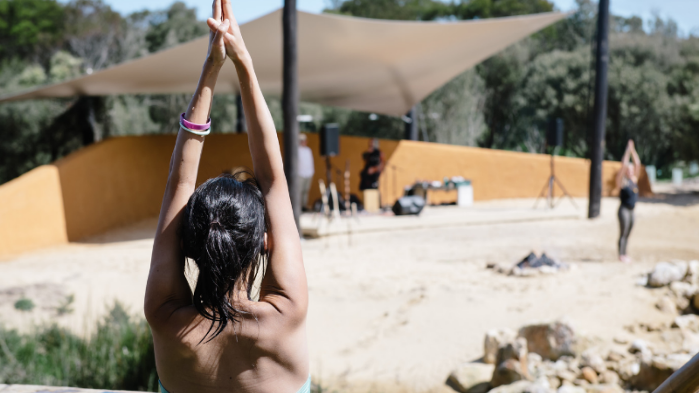 girl doing yoga pose in the hot springs in front of amphitheater stage