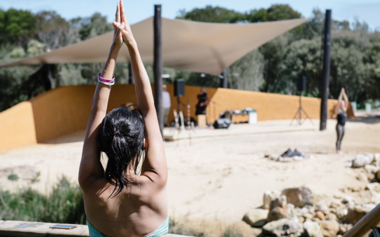 girl doing yoga pose in the hot springs in front of amphitheater stage