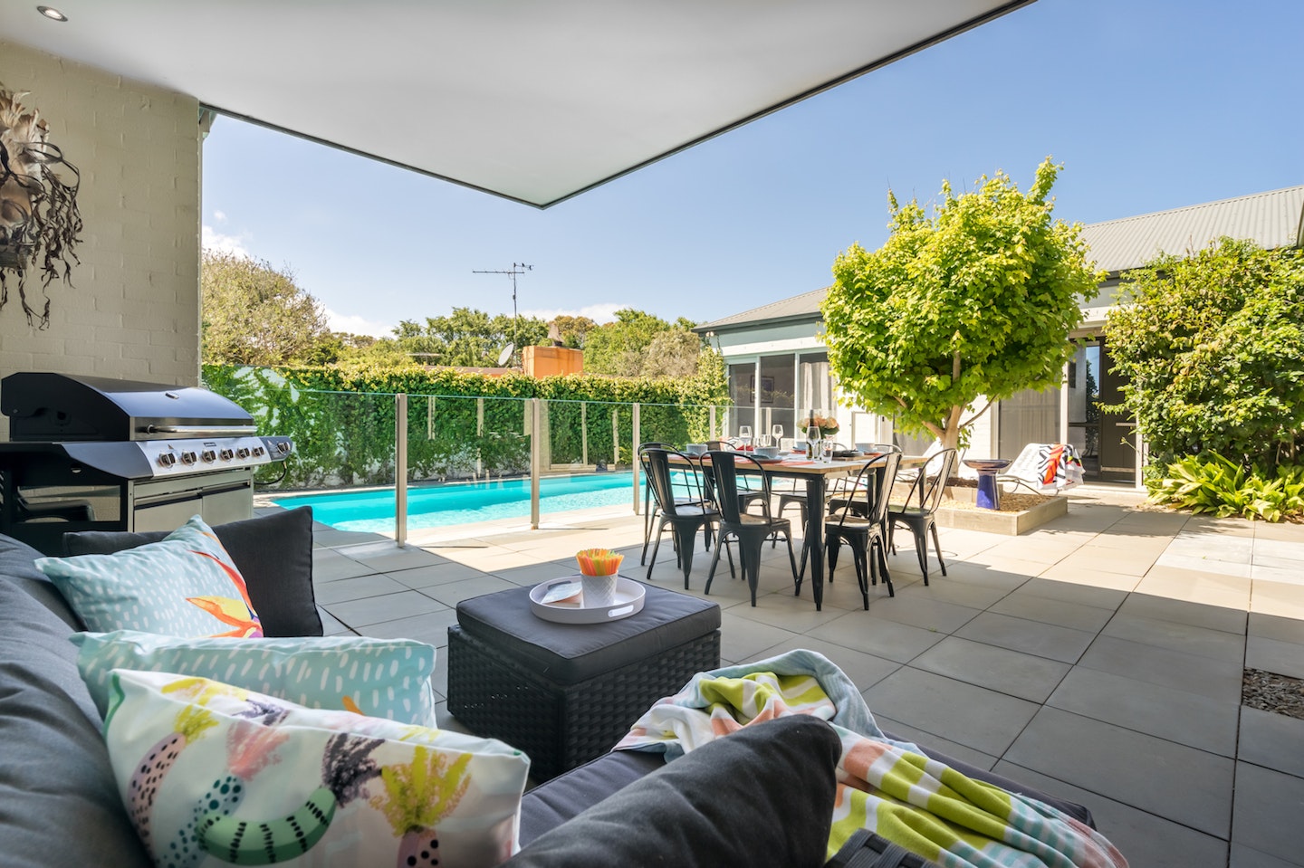 view of inground pool, outdoor dining and barbeque from outdoor sofa