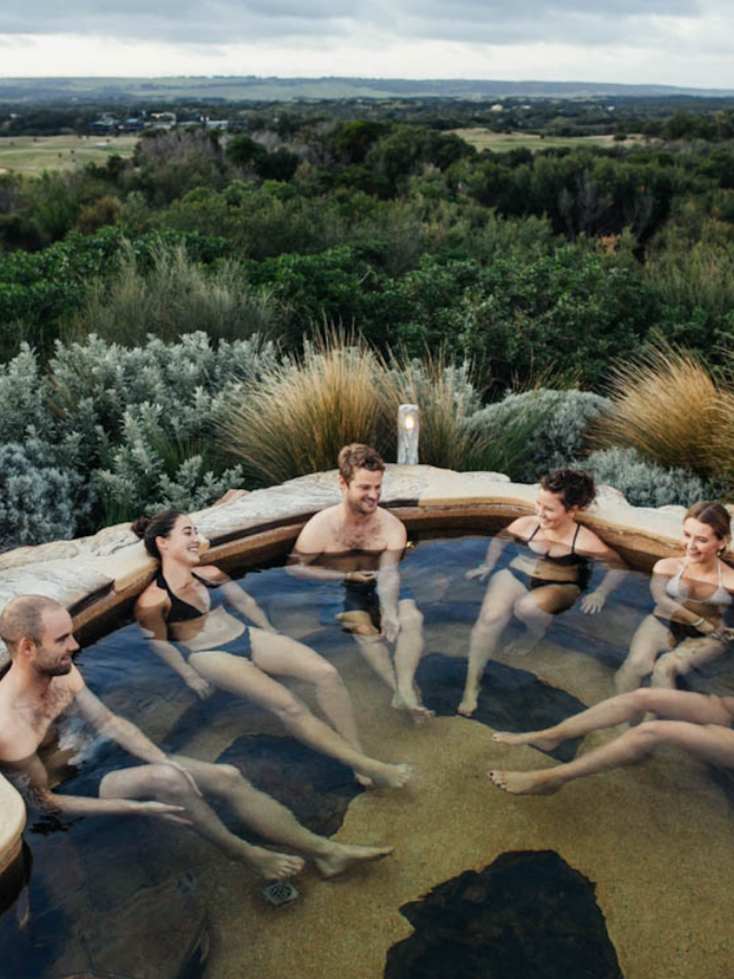 A group of six friends bathing in the hilltop pool