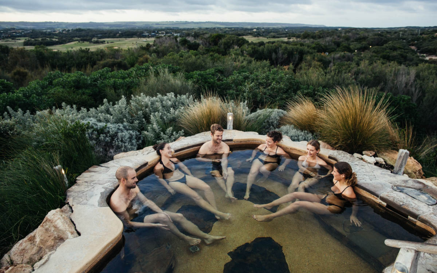 A group of six friends bathing in the hilltop pool