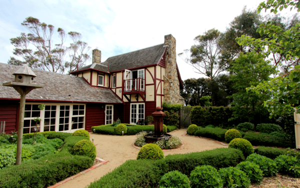 external view of mock tudor home with manicured gardens