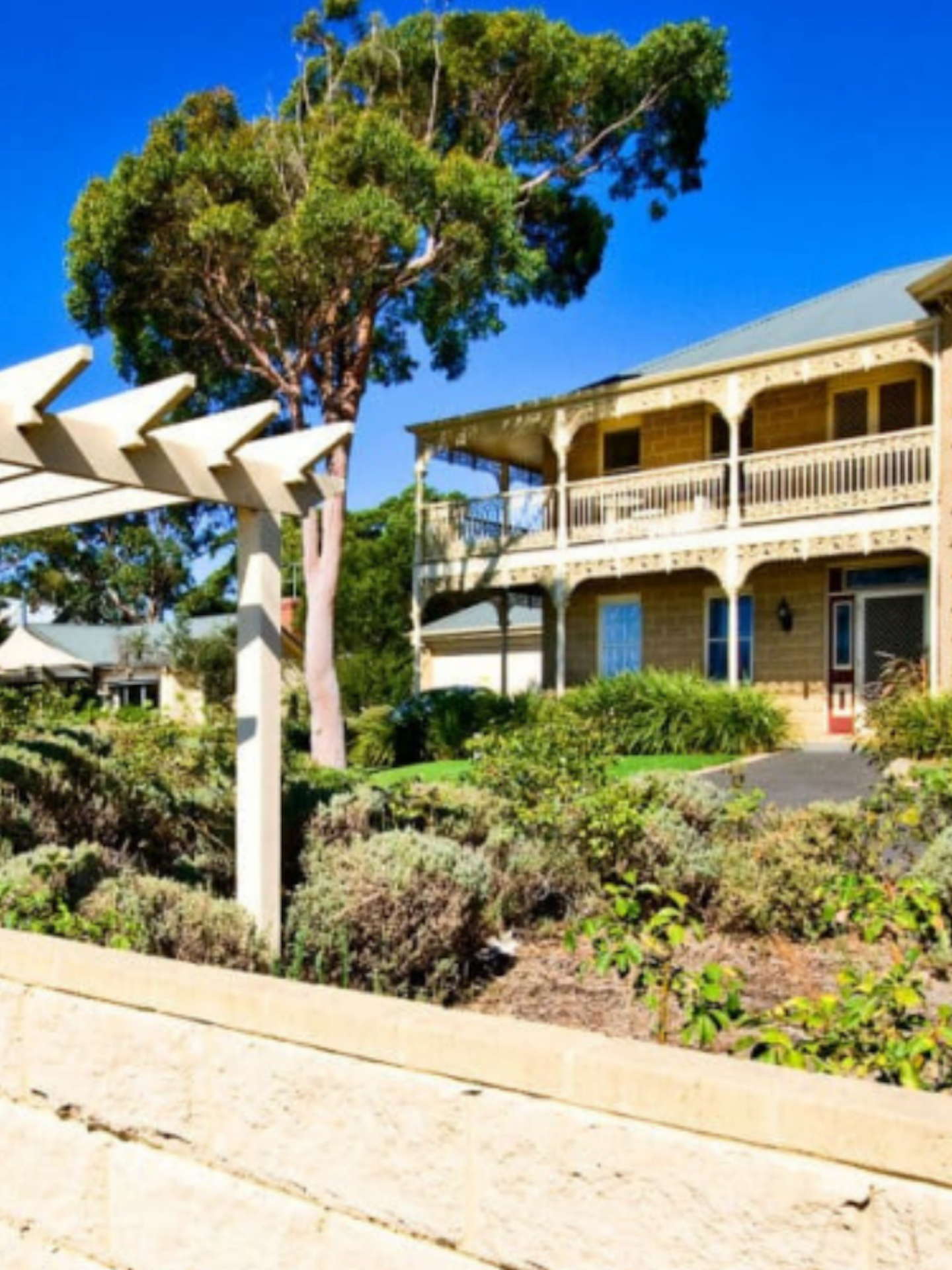 external view of grand sandstone home with manicured gardens