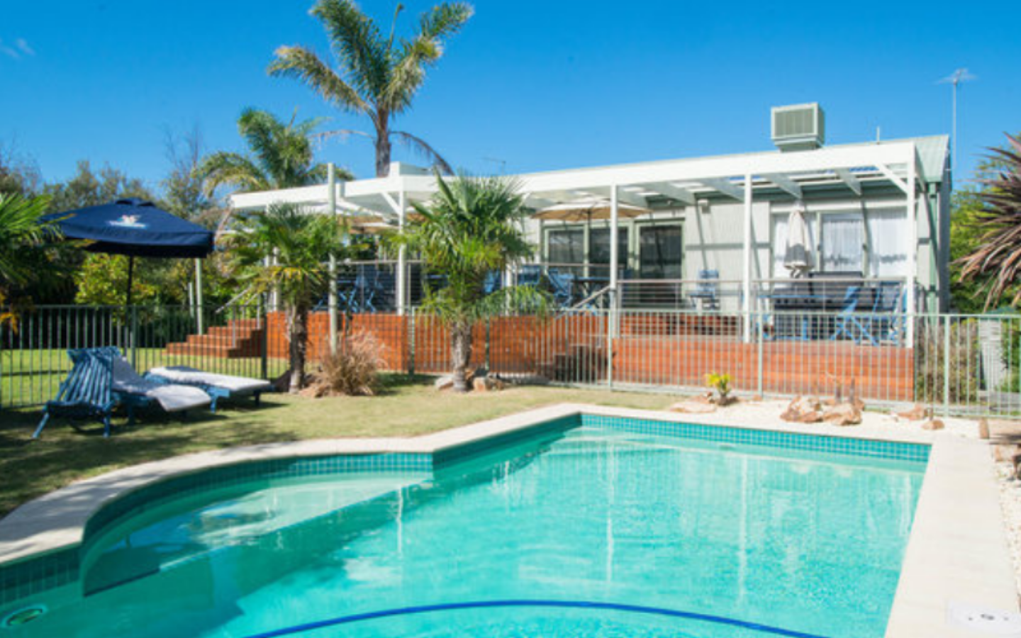 view of gardens and elevated decked area from inground pool